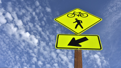 bicycle and pedestrian sign against blue sky