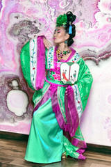 Chinese girl dancing in green traditional dress and fan