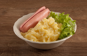 Mashed potatoes with green lettuce and small sausage