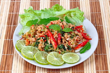 Fried spicy basil with minced pork topped sliced green lemon and and lettuce is top ten of popular Thai food.