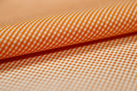 close up roll orange and white scott pattern fabric of shirt