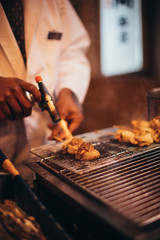 Hand of man take shellfish grill with spoon in Japan 
