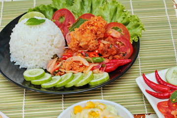 Close up Jasmine rice with spicy fried chicken salad (Khao Yum Kai Zap in Thai) with side dish. Selective focus