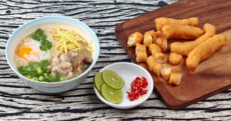 Rice porridge with mined pork and chicken lever served with side dish as Patongko (deep-fried dough stick) and spicy sour filling.