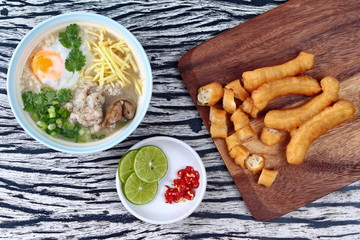 Rice porridge with mined pork and chicken lever served with side dish as Patongko (deep-fried dough stick) and spicy sour filling.