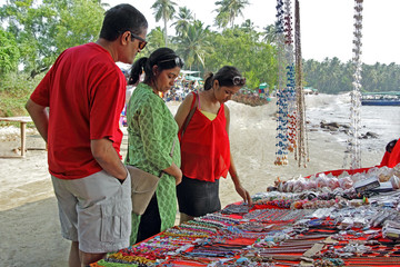 Girl teenager and parents looking for fancy jewelry and accessories in a flea market in Goa, India