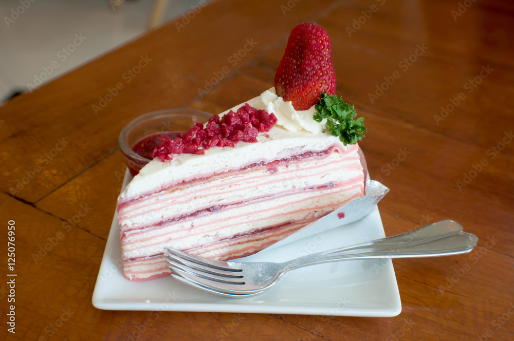 Wall mural crepe cake with strawberry sauce on table.selective focus