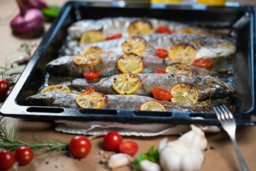 delicious trout fish baked with lemon, tomatoes and spices