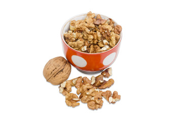 One whole walnut in their shell and shelled kernels closeup
