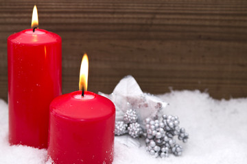 Christmas candles with Christmas decorations on snow