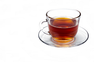 transparent glass cup with tea on a saucer isolated