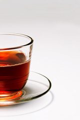 transparent glass cup tea on a saucer on a white background