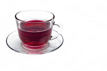 transparent glass cup with Hibiscus tea on a saucer isolated