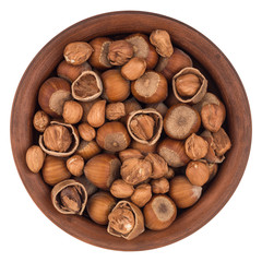 Hazelnuts in a brown plate. Isolated on white background.