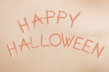 Happy Halloween sign, written in stitches on human skin, horror concept