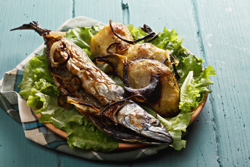 Baked mackerel and potatoes on plate
