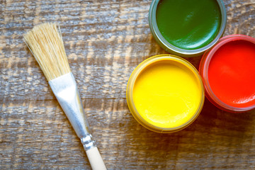 paint cans with brush on a wooden background top view