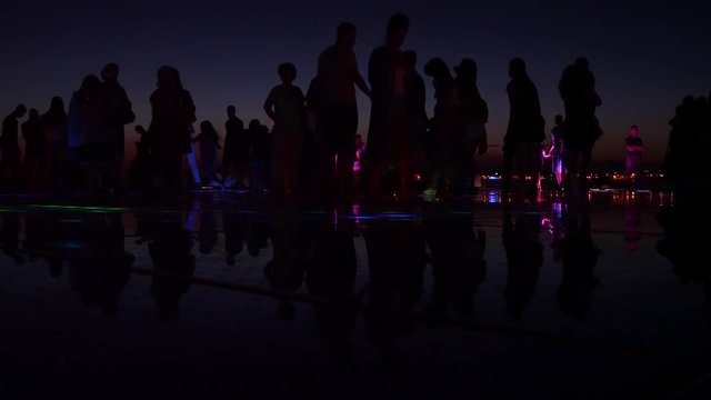 unrecognizable crowd on local place of interest Greeting to the Sun, multilayer glass panels in form of a 22 m diameter circle.