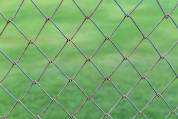Fototapeta premium Pattern rust wall with blurry background of green grass