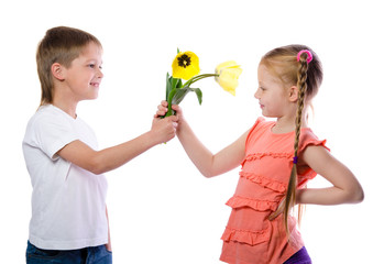 a boy gives a girl yellow tulips on white background