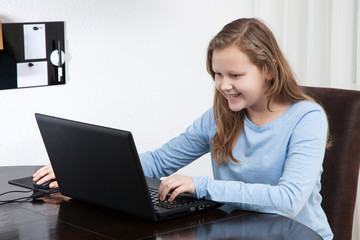 Naklejka premium girl looking to her laptop and smiling