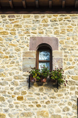 Fototapeta na wymiar Old window with flower pot in Spain