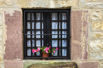 Fototapeta na wymiar Old window with flower pot in Spain