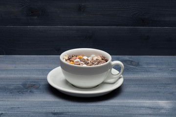 Medical capsules and tablets inside coffee cup