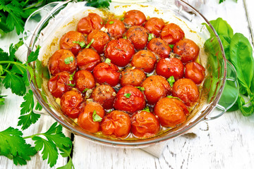Tomatoes baked in pan on board