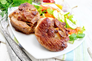 Turkey steak roasted with vegetables on light board