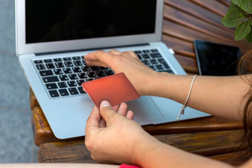 Young woman using her credit card on the street