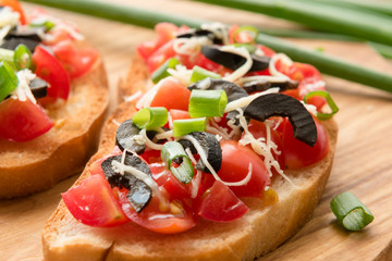 Preparing delicious Italian bruschetta with chopped vegetables