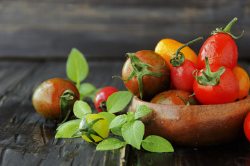 fresh tomatoes with basil on wooden table, selective focus