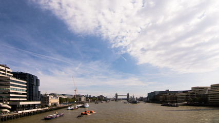 Tower Bridge seen from London Bridge, with cruise boats and clouds