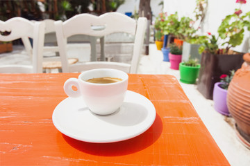 Traditional greek coffee in a cafe with beautiful mediterranean street on the background