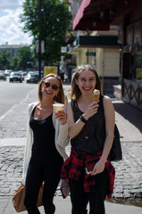 Two girlfriends are eating icecream