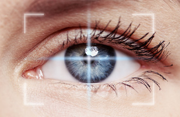 Macro shot of human blue eye with laser rays . Concept of eyesight verification, diagnosis, disease...