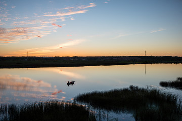 colorful sunrise over the lake with small boat