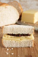 Fototapeta na wymiar Hand cut cheddar cheese and chutney pickle sandwich