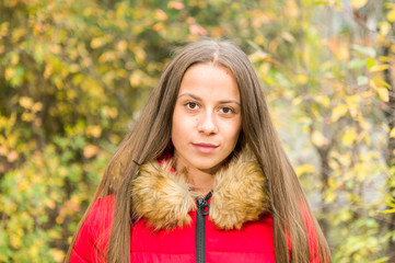 Young woman alone on a forest wearing  red overcoat