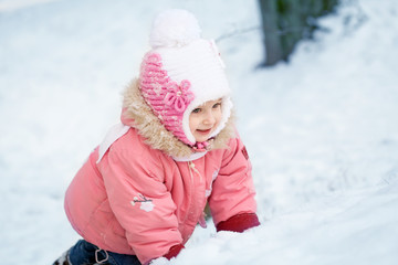 Happy laughing toddler girl in a beautiful snowy winter forest