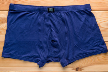 Men's briefs boxers from the blue color cotton on a wooden floor