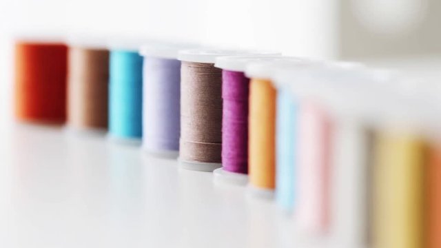 row of colorful thread spools on table