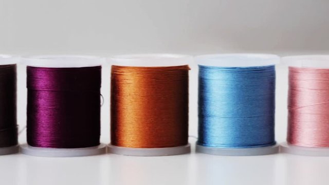row of colorful thread spools on table