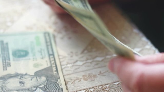 Senior woman counting dollar cash very closeup view.