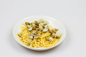 Italian spaghetti with clams in a design plate isolated on a white background
