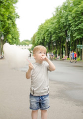 Small baby boy is eating cotton candy