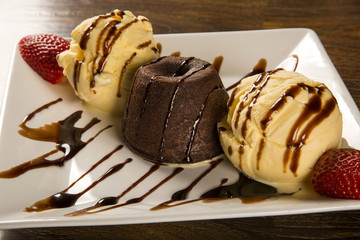 Petit gateau dessert with ice cream and strawberry on wooden bac