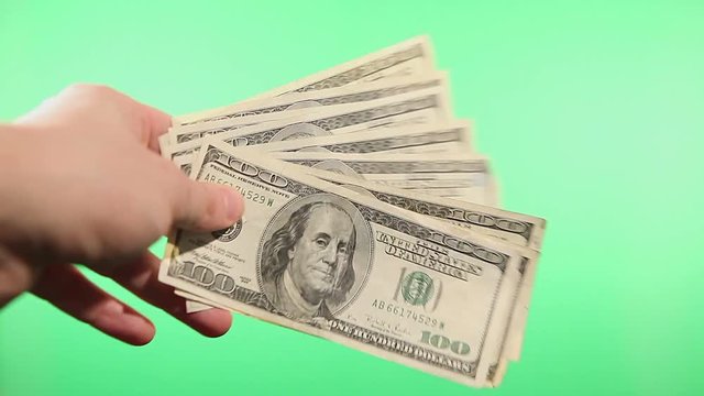 Close up of hans waving with paper us dollars
