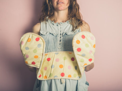 Young woman with oven gloves